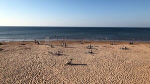 A wide sandy beach with a clear sky, several lifeguard stands, and people scattered across the sand. - Waterfront Vacation Home-4 bedrooms-2.5bath-Laundry room inside-2 heat pumps (York)