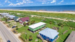 A coastal property with multiple buildings, a beach, and a road.