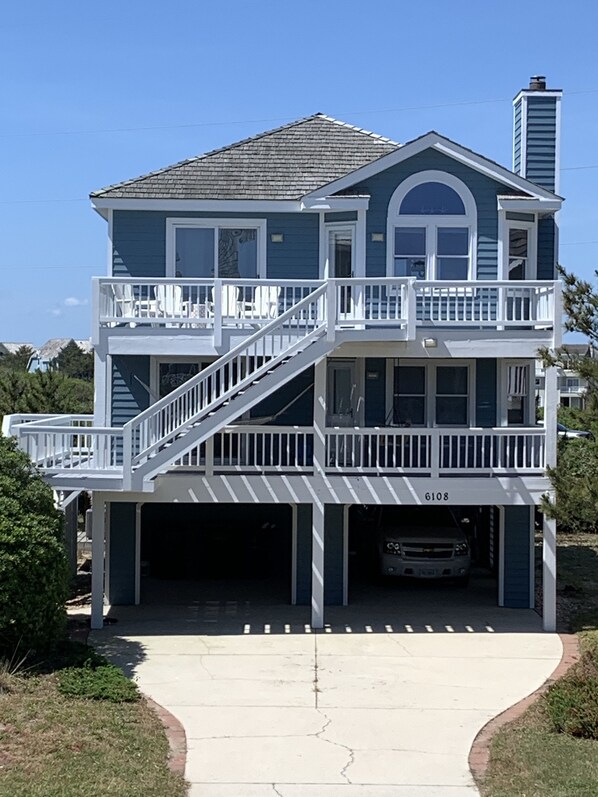 A two-story house with a balcony, a garage, and a driveway.
