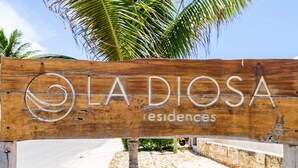Un letrero de madera con el texto "LA DIOSA residences" y un logotipo.