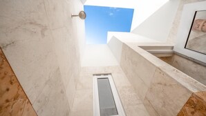 Un baño moderno con tragaluz, ducha y bañera.