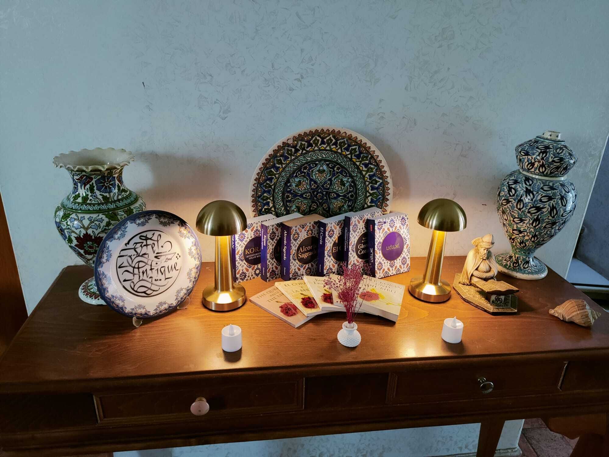 A wooden desk with decorative items including a vase, a plate with calligraphy, a patterned plate, a lamp, and a small statue.