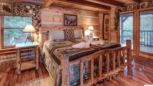 Une pièce rustique en bois, avec un grand lit, deux tables de chevet équipées de lampes et une fenêtre avec des stores.