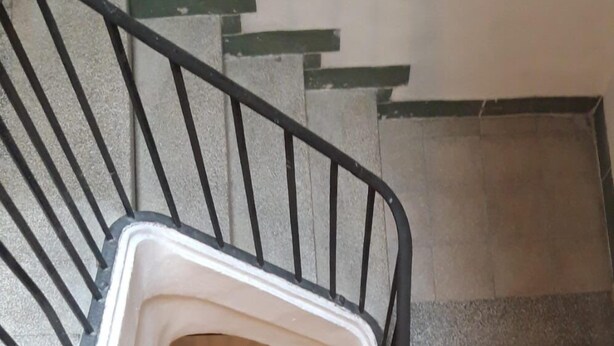 A spiral staircase with a central handrail and a small enclosed area at the bottom. - Apartment Cos del Bou (Tarragona)