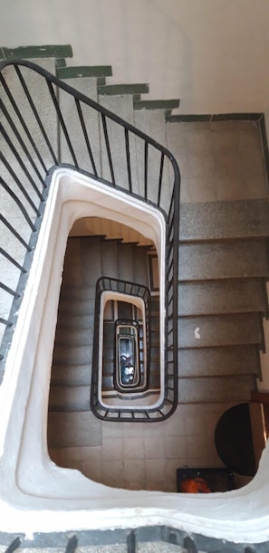 A spiral staircase with a central handrail and a small enclosed area at the bottom. - Apartment Cos del Bou (Tarragona)