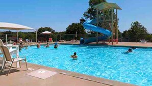 A swimming pool with a water slide, lounge chairs, and umbrellas. - Alpine in the Ozarks~ right off back 40 trails (Bella Vista)