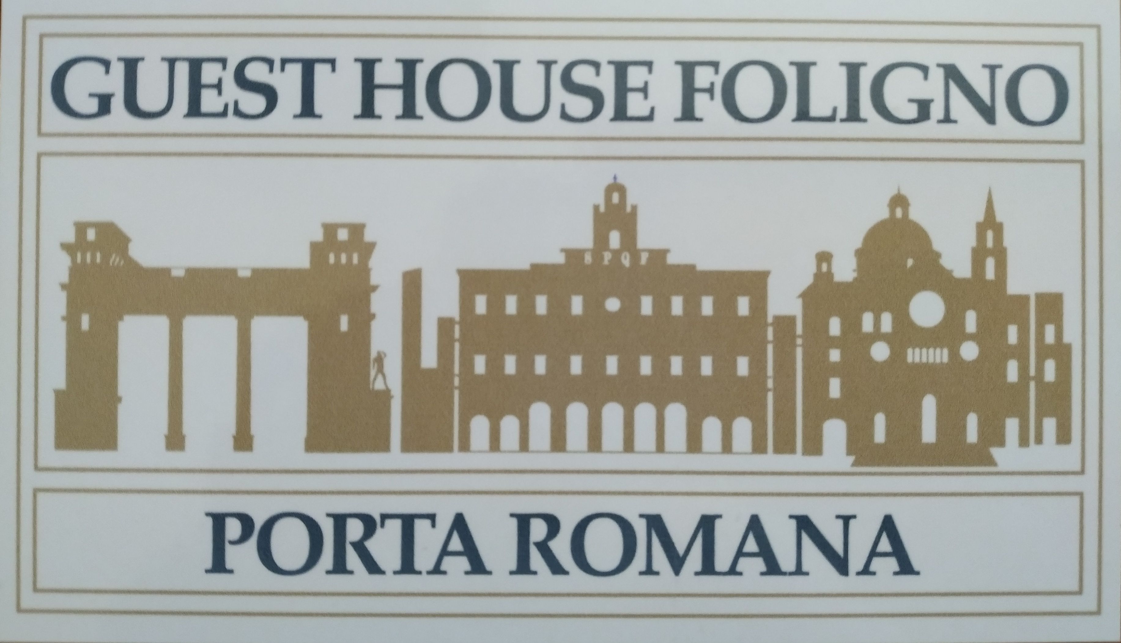 A sign with the text "GUEST HOUSE FOLIGNO" and "PORTA ROMANA" along with silhouettes of architectural landmarks.