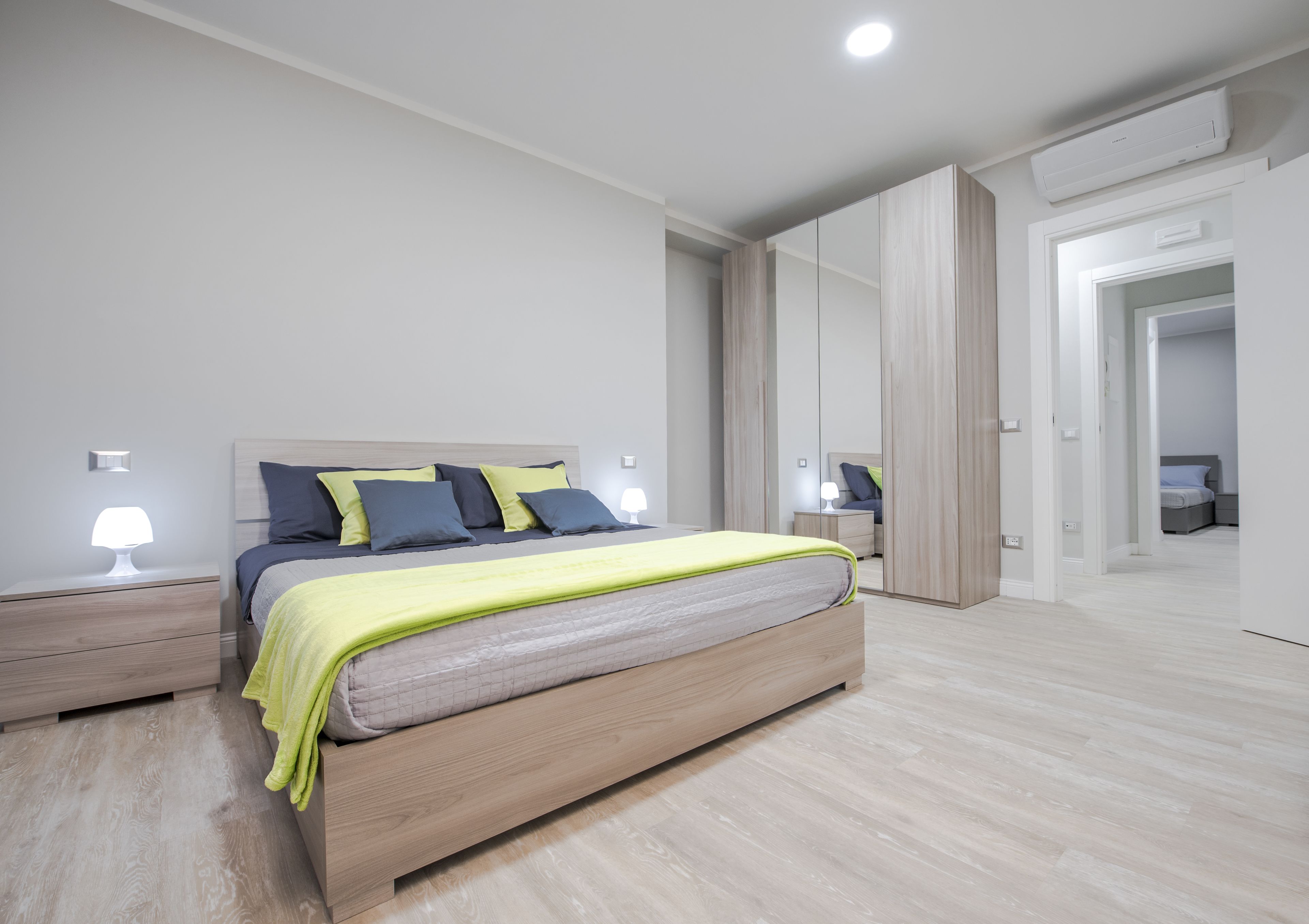 Una camera da letto moderna con un letto grande, comodini e un armadio.