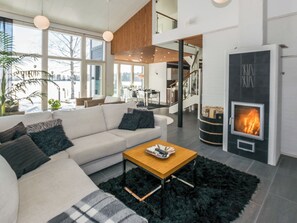 A modern living room with a sofa, coffee table, and fireplace. - Villa kaivopuisto by Interhome (Lavia)