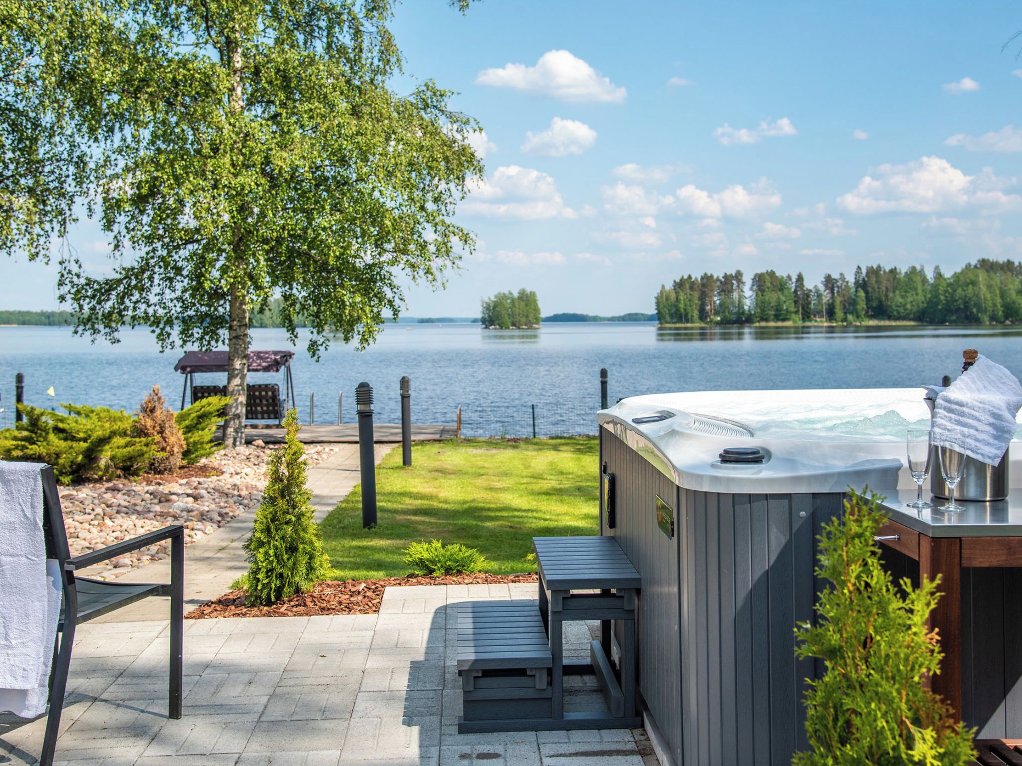 Un bain à remous avec vue sur un lac, une table de pique-nique et un espace de détente abrité.