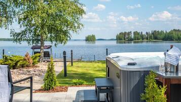 Un bain à remous avec vue sur un lac, une table de pique-nique et un espace de détente abrité.