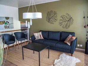 A modern living room with a sofa, chairs, a coffee table, and decorative wall art. - Villa kaivopuisto by Interhome (Lavia)