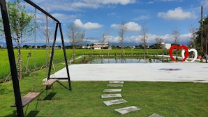 A park with a swing set, a heart-shaped sculpture, and a pathway. - Honeysuckle Family Castle (Wujie)