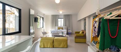 Una habitación de hotel moderna con una cama, un escritorio, una silla y un perchero.