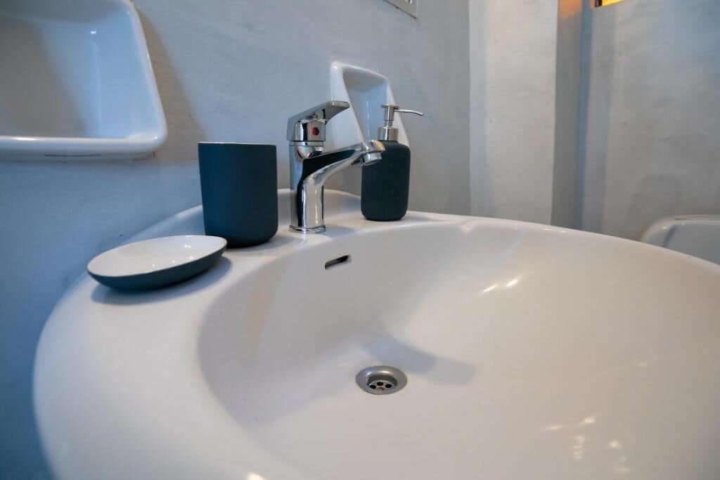 A white bathroom sink with a modern faucet and soap dispenser.