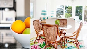 A modern kitchen with a white countertop and a bowl of fruit. - Coral Beachside - Private Beach Resort (Greenwood)