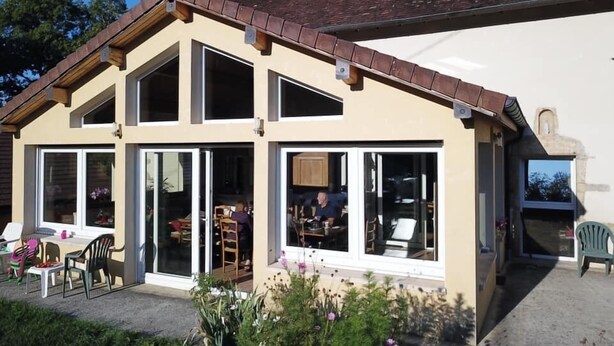 A two-story building with large windows and a sloped roof. - Chambres d'Hôtes La ferme de montard (Montmorot)