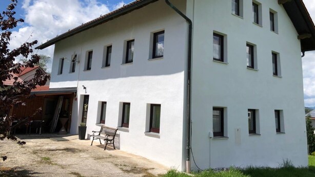 Ein zweistöckiges Gebäude mit vielen Fenstern und einem geneigten Dach.