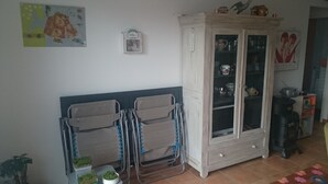 Een woonkamer met een kast, een radiator en een televisietoestel.