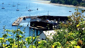 Un port marítim costaner amb vaixells amarrats, un moll i una platja al fons.