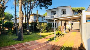 Una propiedad residencial con un patio cubierto, un césped cuidado y un cielo despejado.