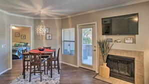 A dining area with a chandelier, a fireplace, and a television mounted on the wall. - "Scottsdale Gem Near Pickleball Courts & Park!" (Scottsdale)