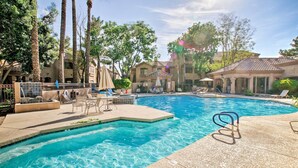 A swimming pool with lounge chairs and umbrellas, surrounded by palm trees and buildings. - "Scottsdale Gem Near Pickleball Courts & Park!" (Scottsdale)
