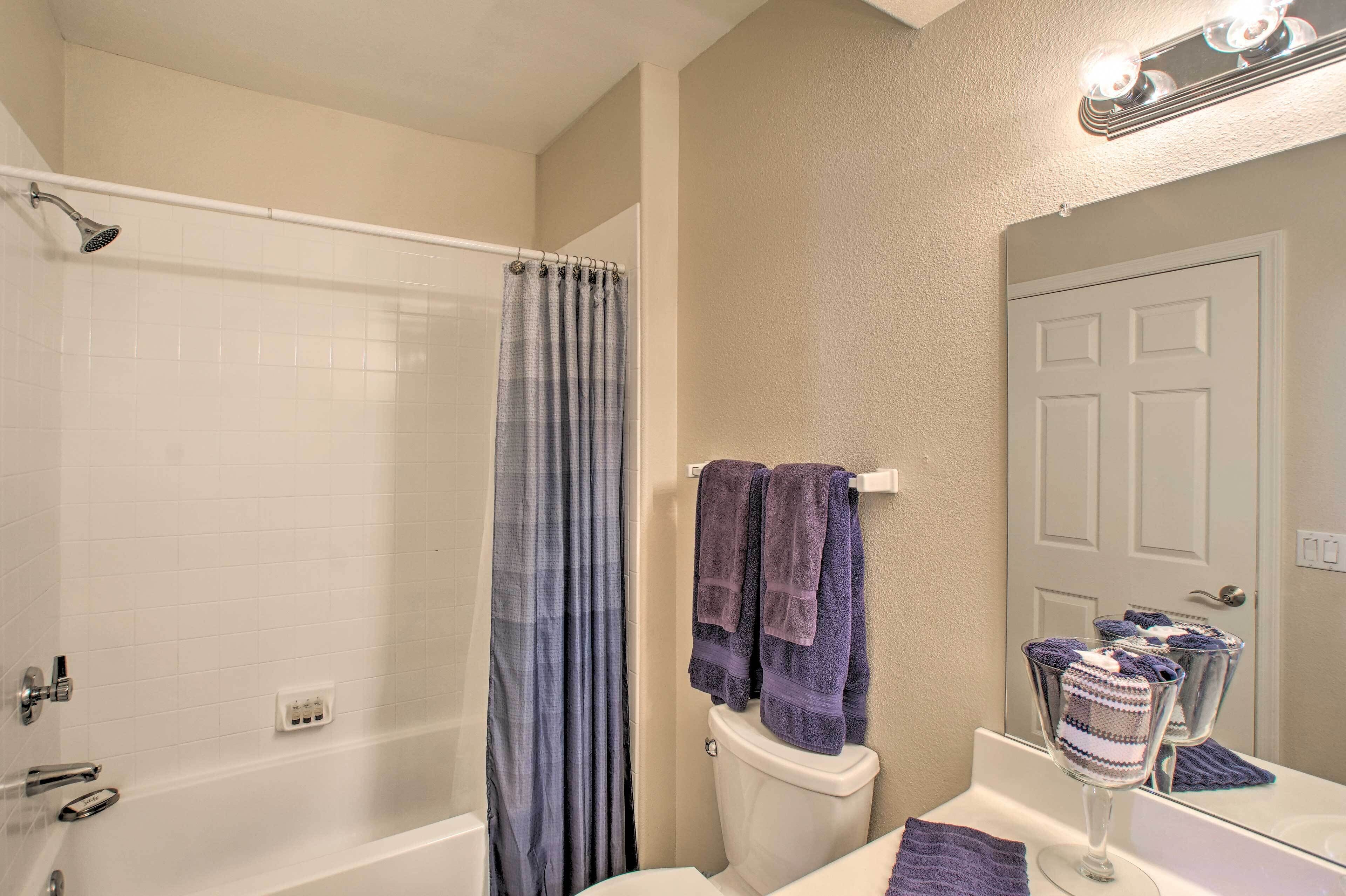A bathroom with a shower, toilet, and sink.