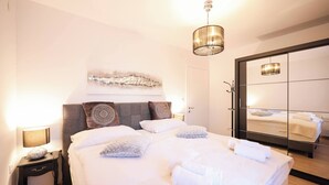 Ein ordentlich bezogenes Bett mit weißen Leinen und Kissen, eine Nachttischlampe und ein Wandbild über dem Bett.