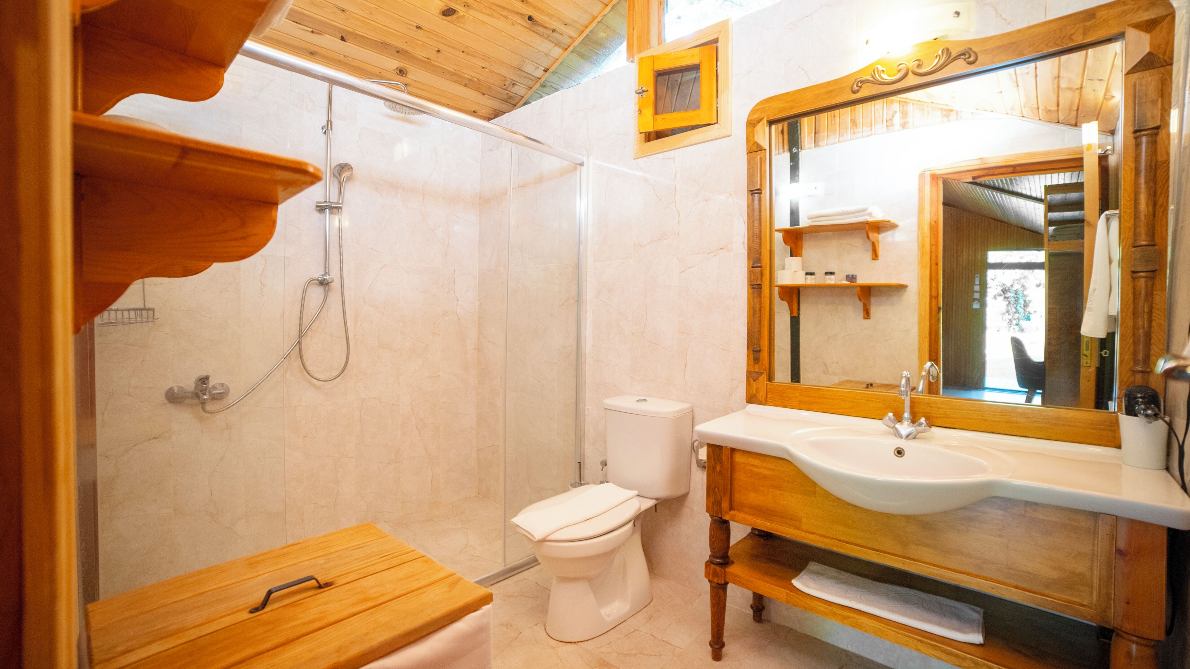 A bathroom with a wooden vanity, a sink, a toilet, and a shower.
