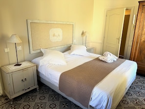 A hotel room with a bed, a nightstand, a lamp, a mirror, and a wardrobe. - Auberge du Cellier (Montner)
