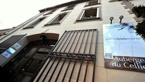 Fachada de um edifício com uma placa indicando 'Auberge du Cellier' e 'Restaurant Chambres'.