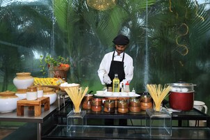 Un chef preparando comida en una cocina con distintos utensilios y productos alimenticios.
