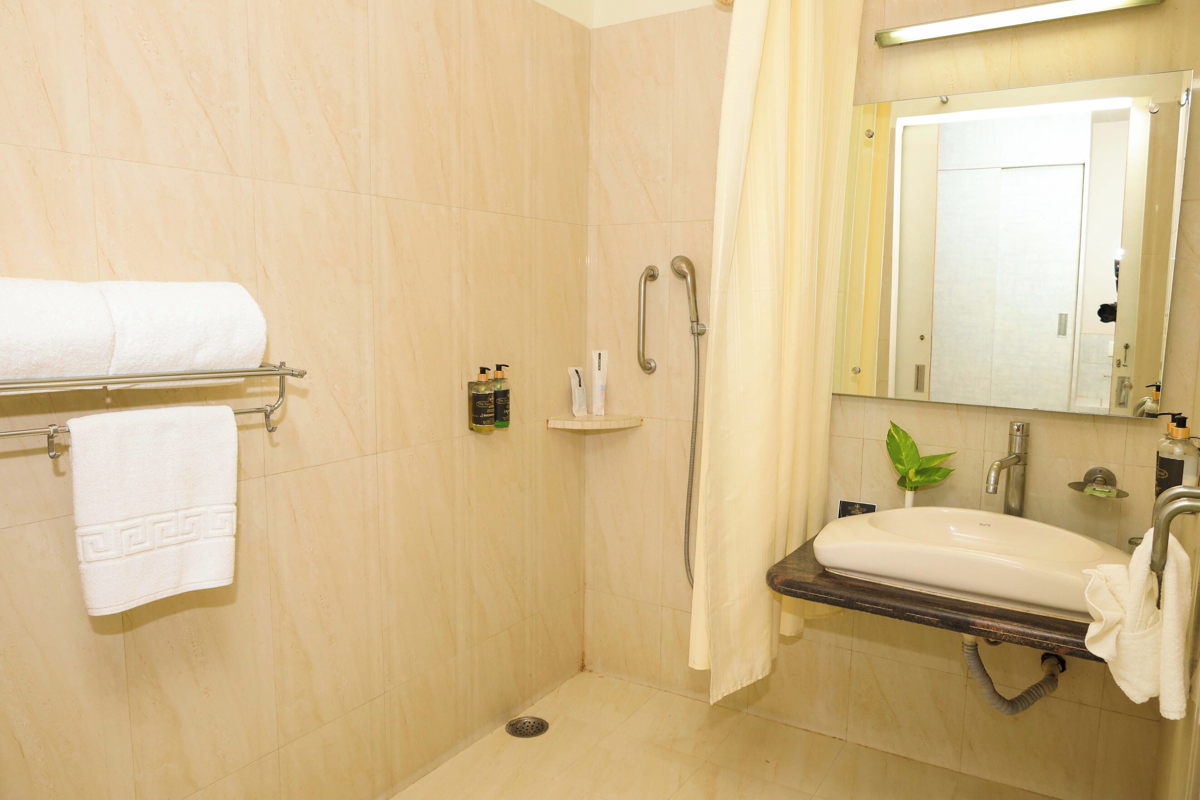 A bathroom with a shower, a sink, a towel rack, and a mirror.