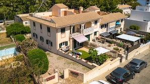 A multi-story building with a balcony, a swimming pool, and a view of the sea.