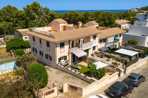 Un immeuble à plusieurs étages doté d’un balcon, d’une piscine et offrant une vue sur la mer.