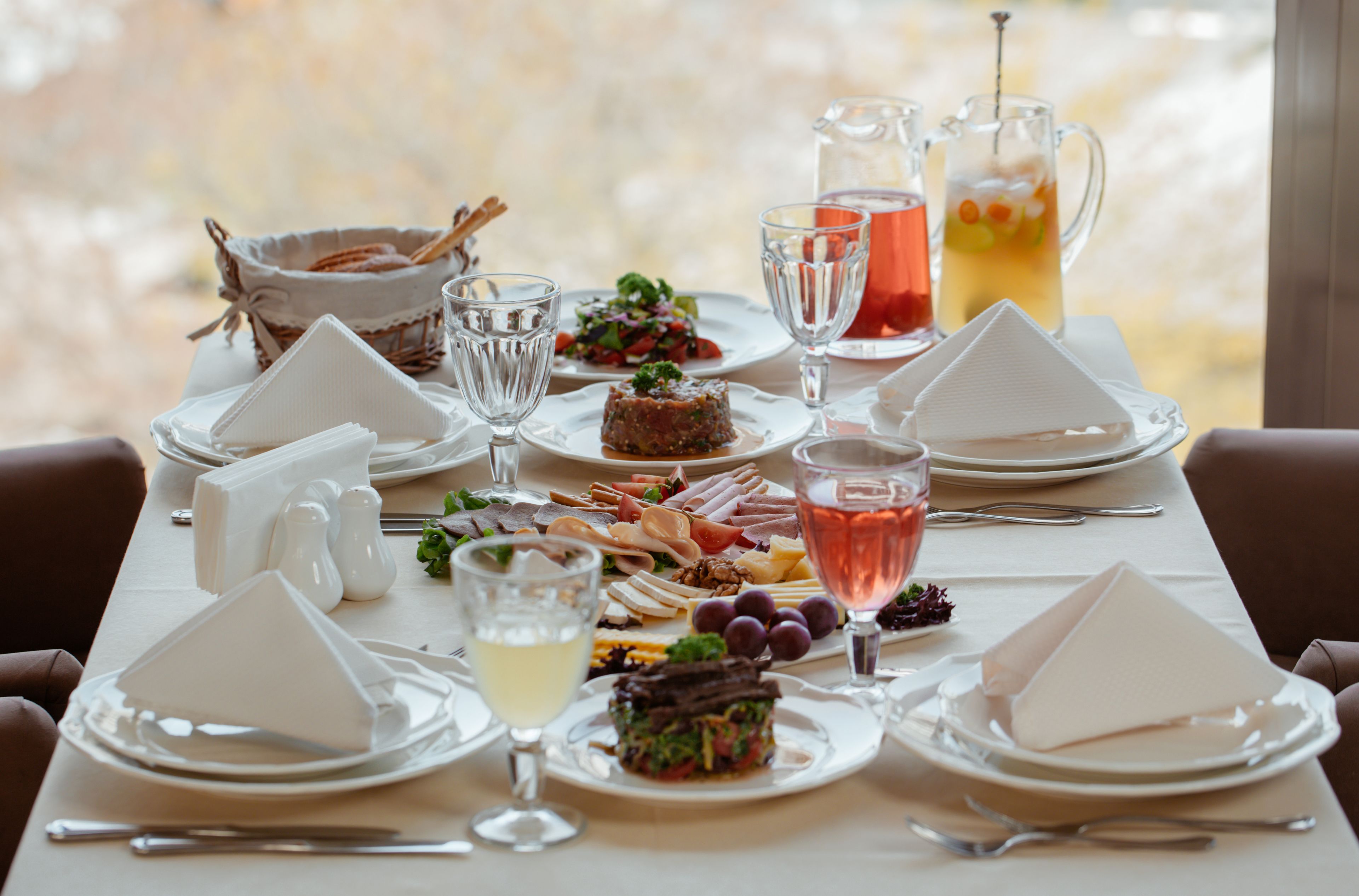 Una tavola apparecchiata per un pasto, con piatti, bicchieri e un boccale di bevanda.