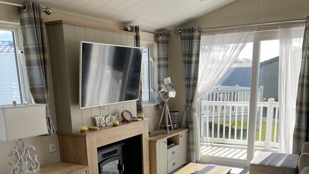 Een gezellige woonkamer met een open haard, een televisie en comfortabele zitplaatsen.