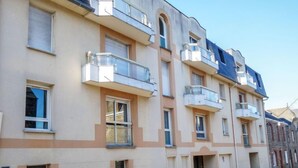 A multi-story residential building with balconies, a central entrance, and a uniform facade. - Le Hoche by Interhome (Dinard)