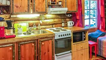 Een koelkast, een microgolfoven, kookgerei, borden en bestek