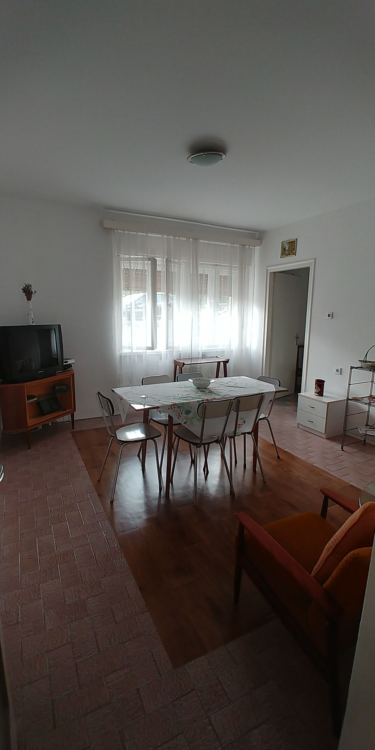 A spacious living room with a dining area, a television, and a fireplace.