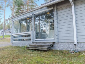 A house with a covered porch, large windows, and a stone foundation. - Karjalan heili 17 by Interhome (Lieksa)
