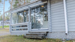 Une maison moderne dotée de grandes fenêtres et d’un porche abrité.
