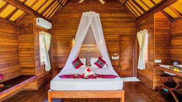 Quarto de cabana de madeira com uma cama, uma escrivaninha e uma cadeira.