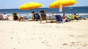 A beach with several sun umbrellas and beach chairs.