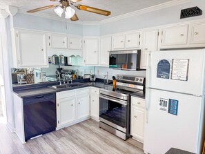 A kitchen with white cabinets, a stainless steel range, and a dishwasher. - Inlet Point Villas 4C (North Myrtle Beach)