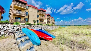 A beachfront hotel with multiple balconies and a sandy foreground. - Inlet Point Villas #4C! Relax & Recharge in Cherry Grove’s Most Peaceful Corner (North Myrtle Beach)