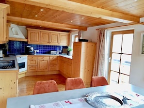 A kitchen with wooden cabinets, a stove, and a sink.