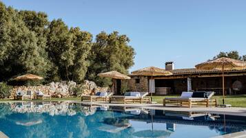 Een buitenzwembad, parasols voor strand/zwembad