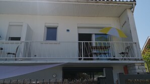 A two-story house with a balcony, a small window, and a door. - La Luciole – 3★ bright & comfortable apartment by the sea (ronce les bain)
